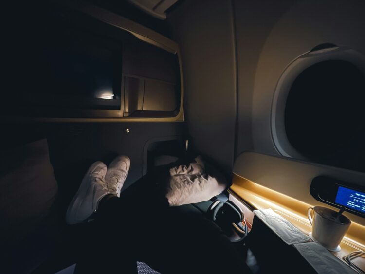 A person sleeping on an airplane in the dark