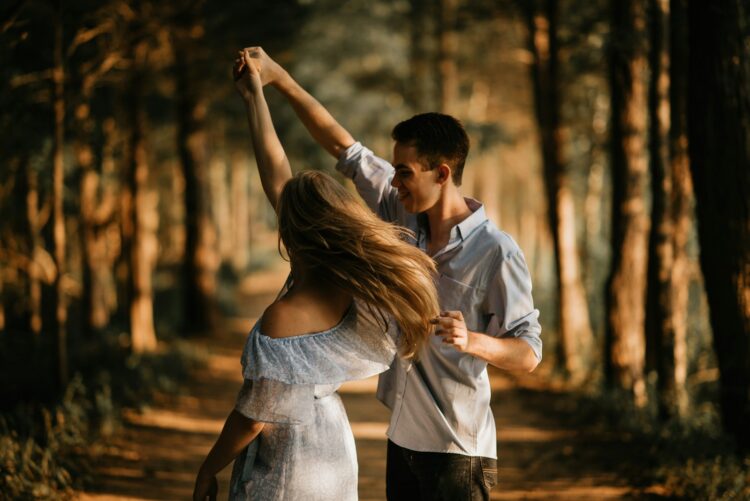 Man and woman dancing at center of trees