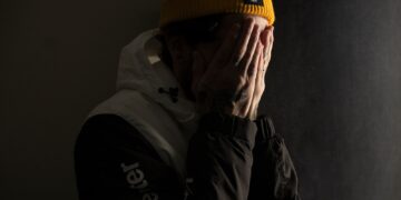 man covering his face with both hands