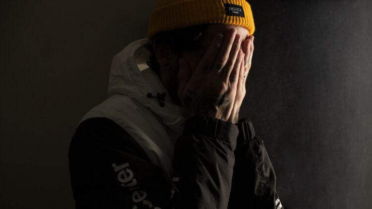 Man covering his face with both hands