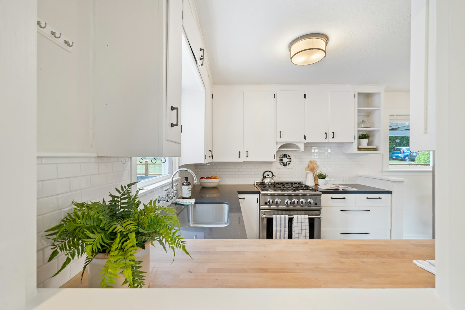 White wooden kitchen cupboards and gray gas stove