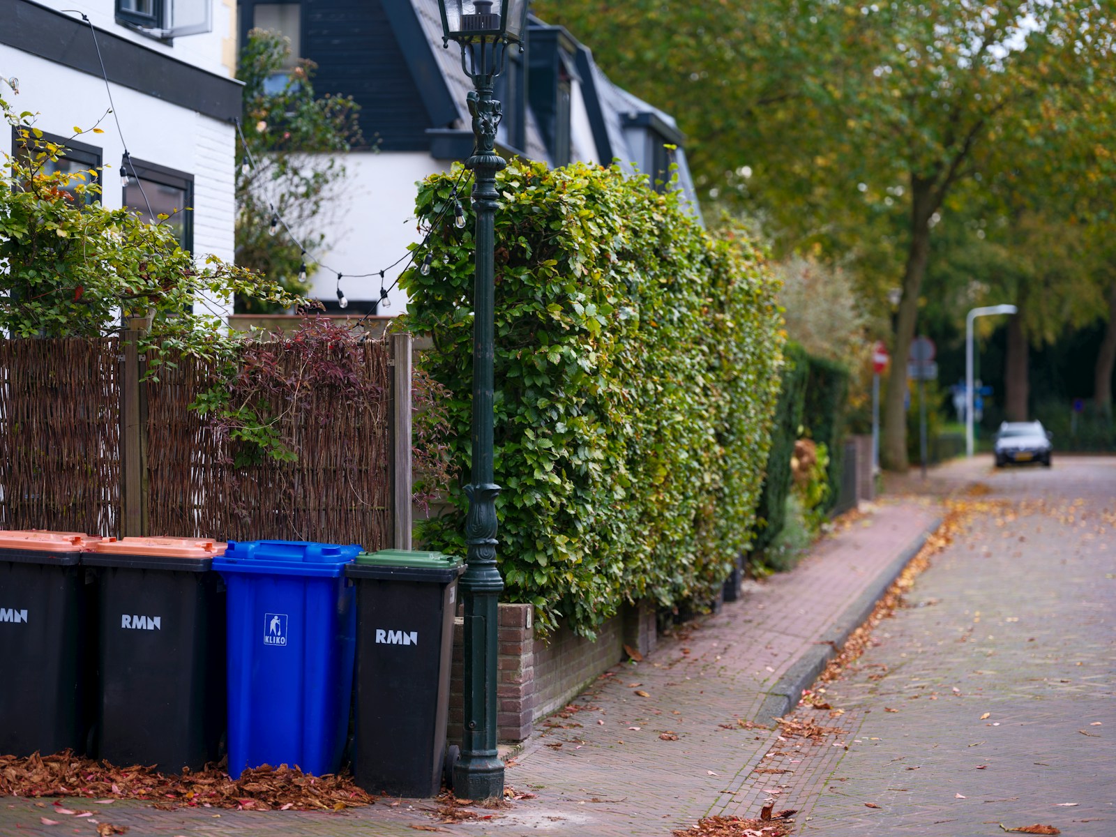 A row of trash cans sitting on the side of a road