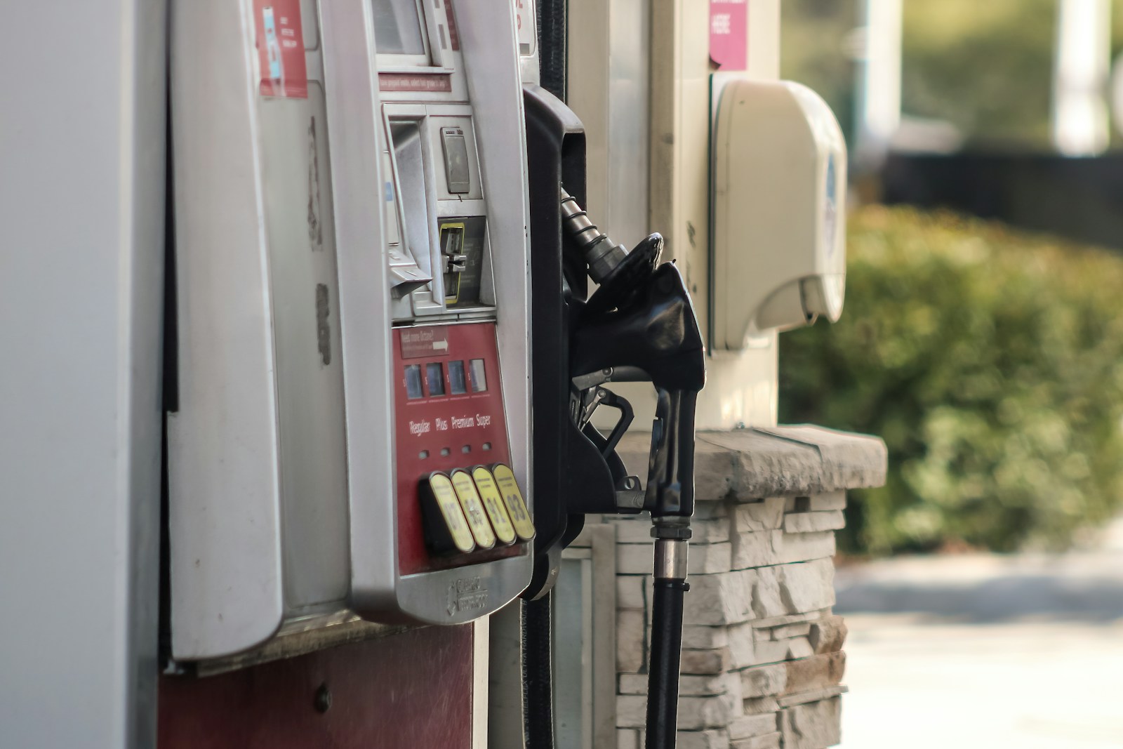 A gas pump next to a brick wall