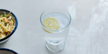 a glass of water with a lemon slice on top