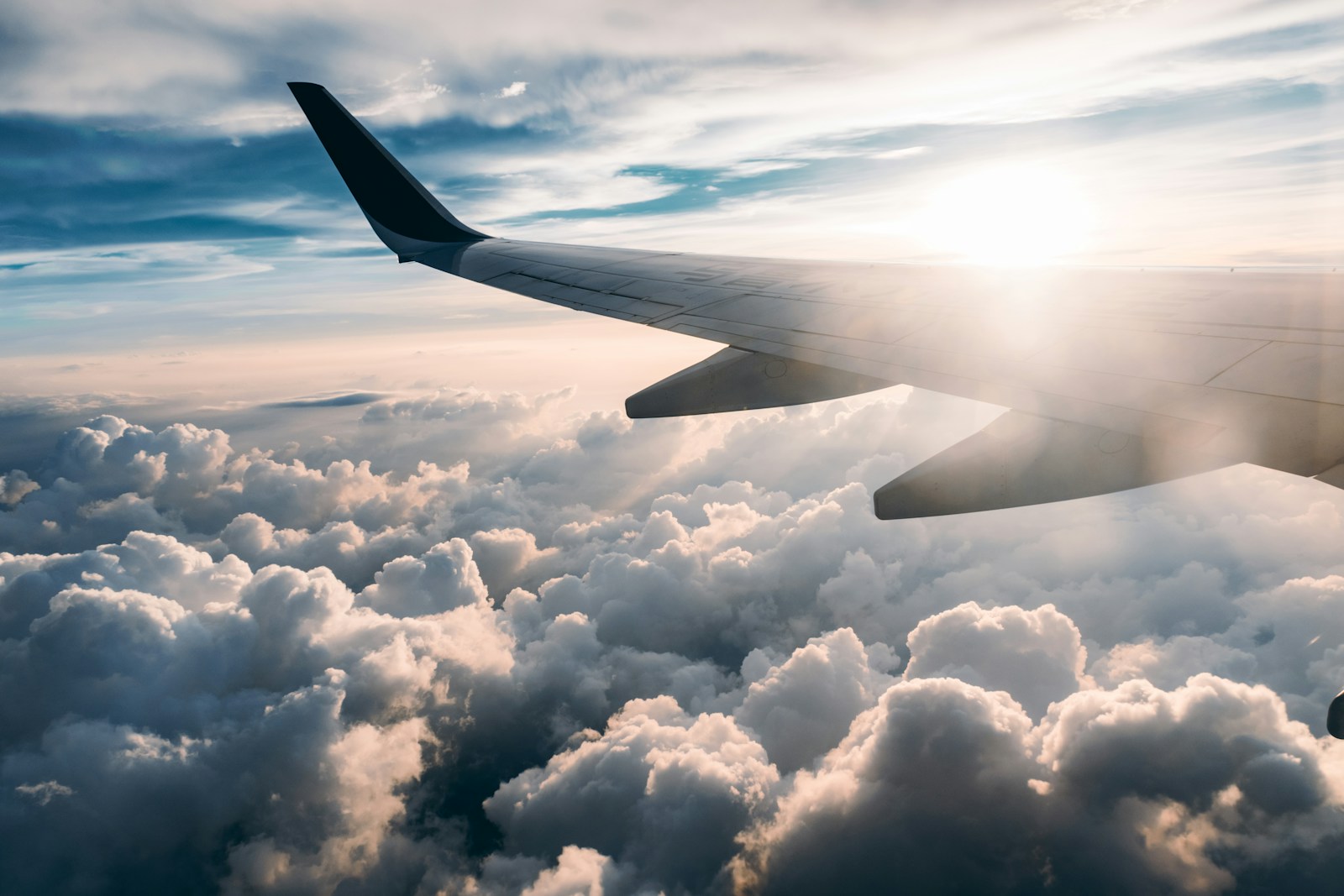 Flying airplane over white clouds