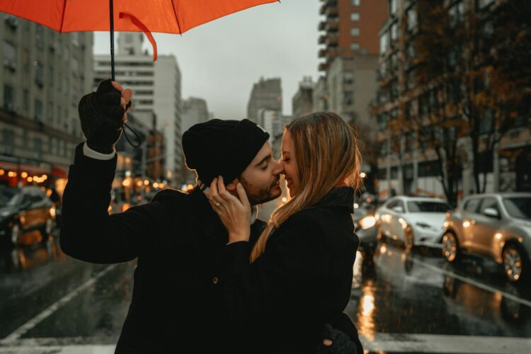 Woman in black jacket holding red umbrella during daytime