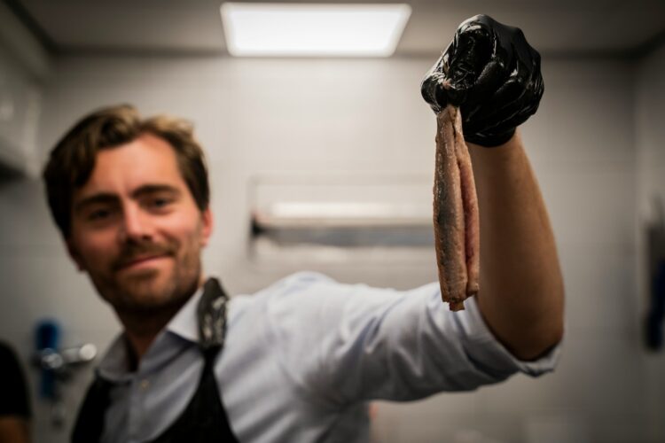 A man holding a piece of meat in his hand