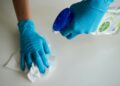 Person in blue gloves holding white textile