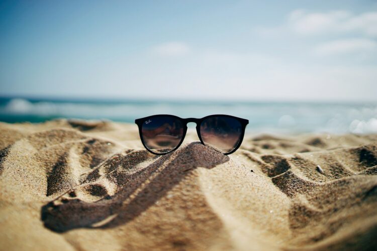 Black ray ban wayfarer sunglasses on beach sand