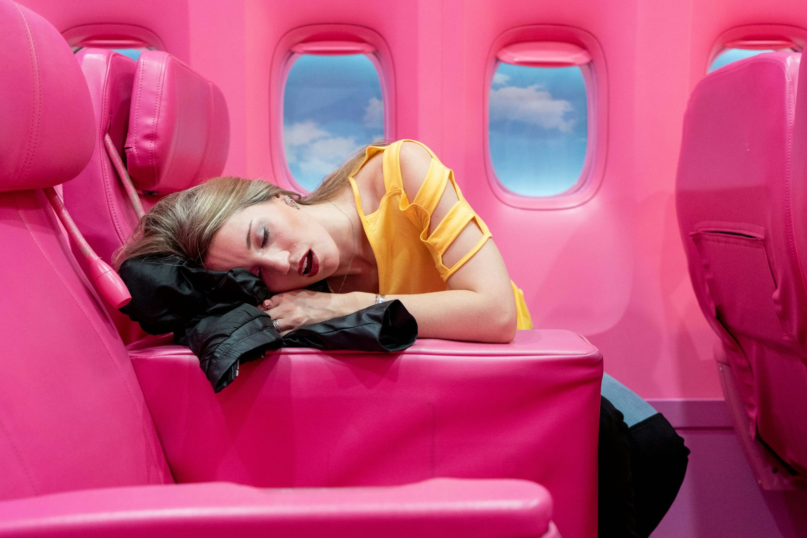 Girl in yellow long sleeve shirt lying on red inflatable bed