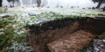 a grave in the middle of a field covered in snow