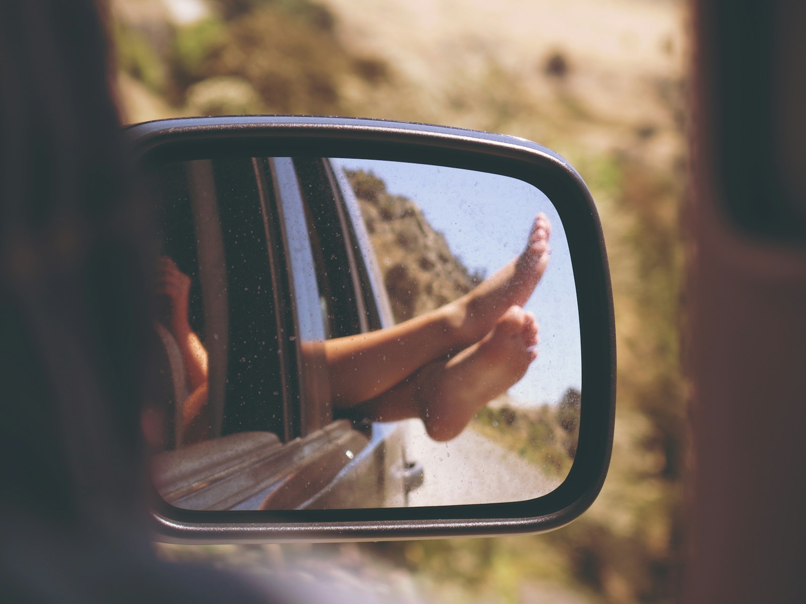 Person's leg resting on vehicle window