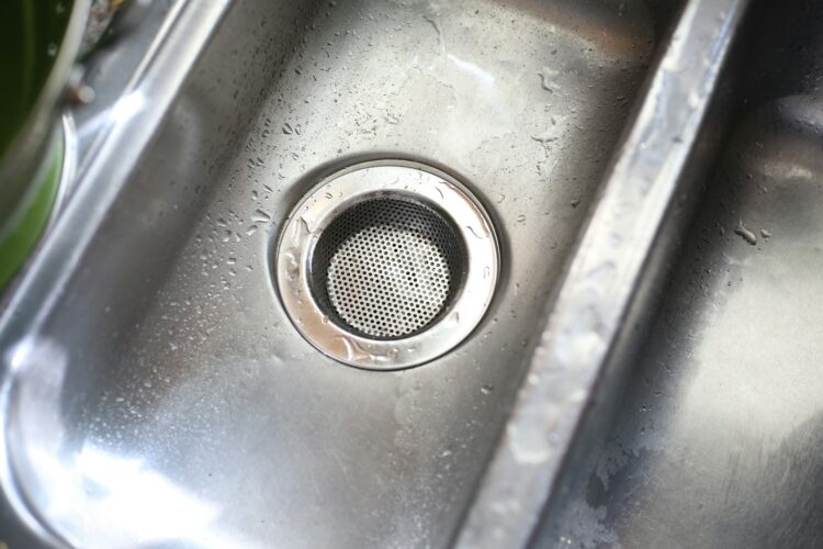 A stainless steel sink with a strainer in it