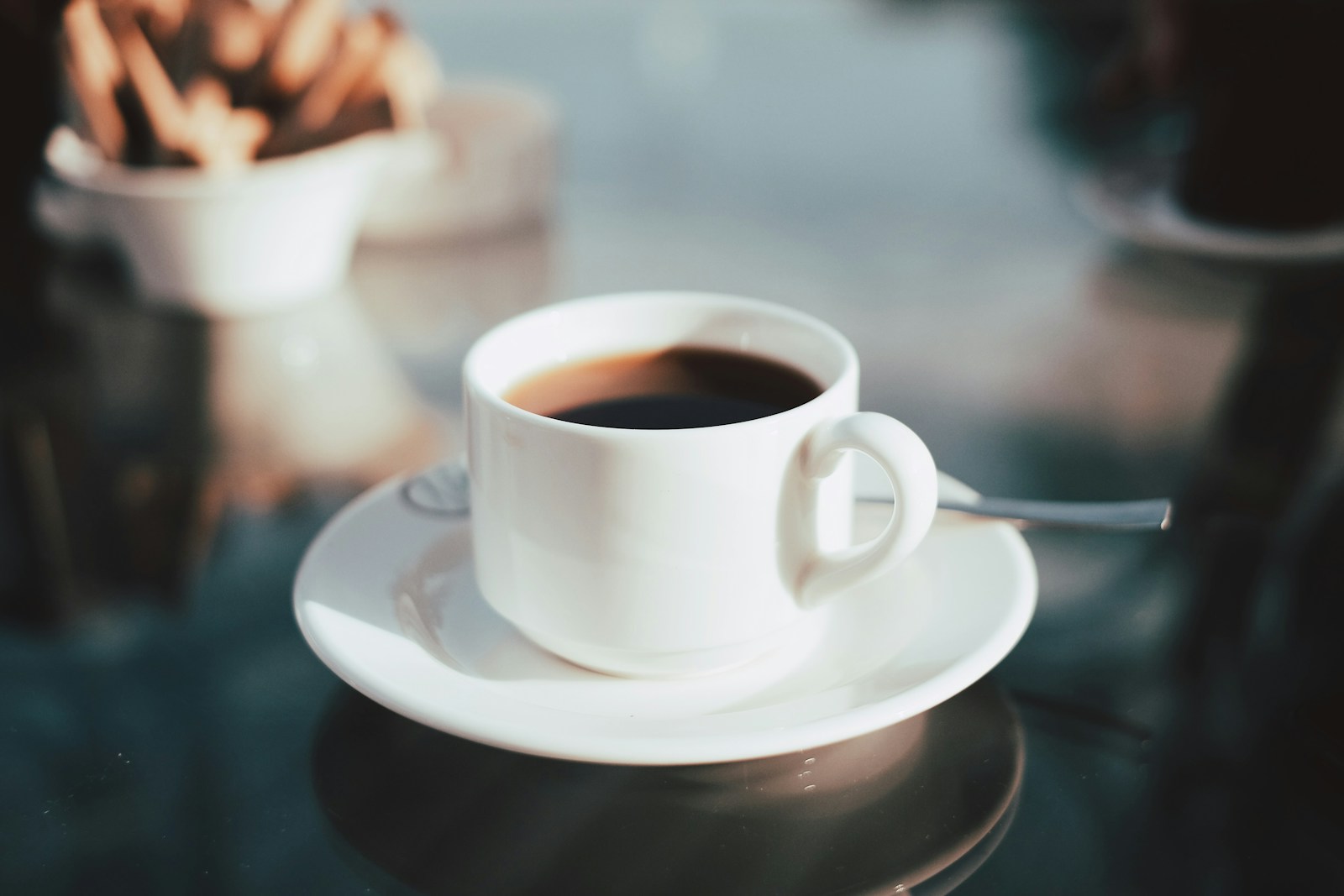 Cup of coffee on white ceramic saucer