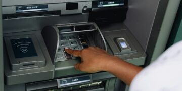a person using an atm machine to pay money
