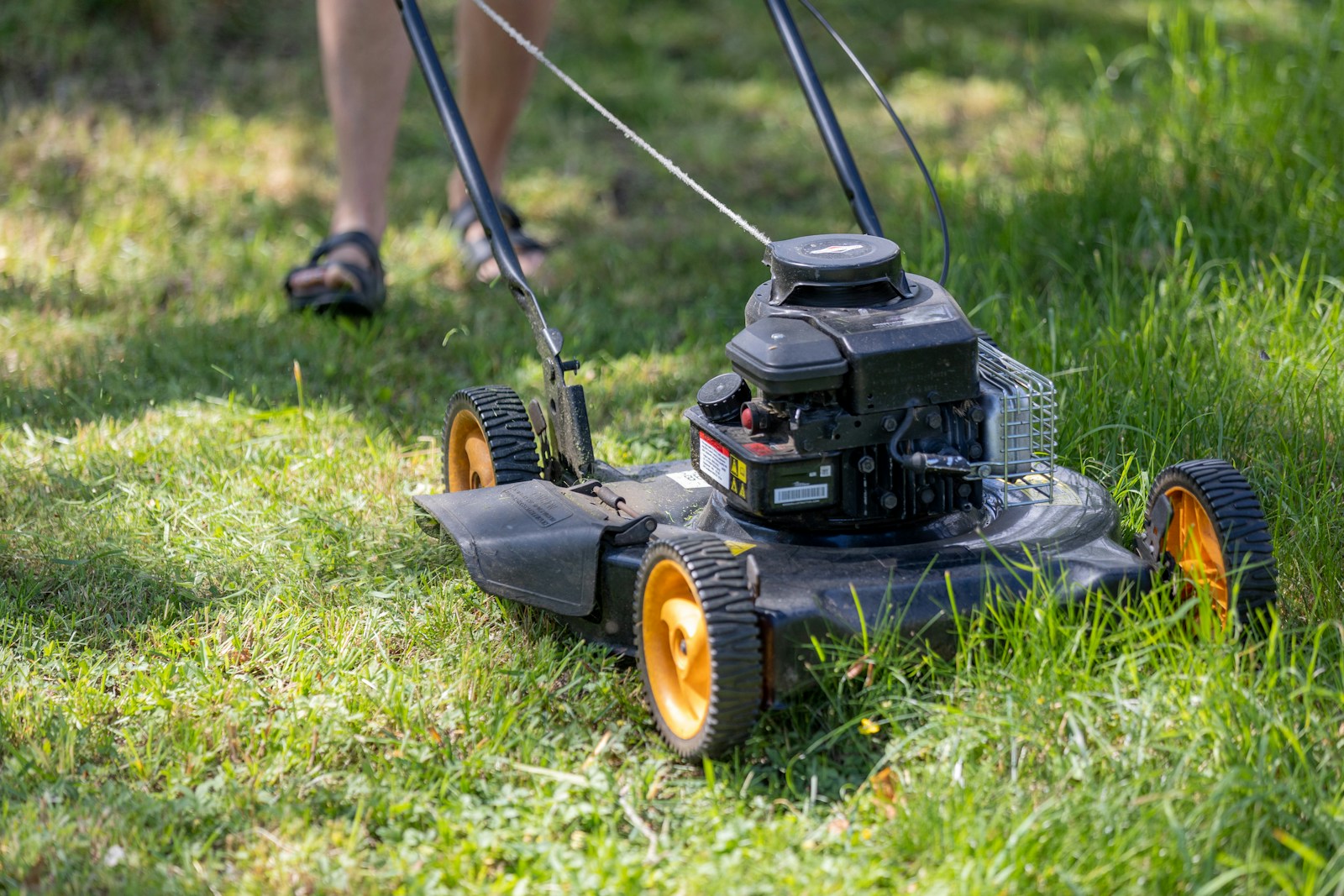 A person mowing the grass with a lawn mower