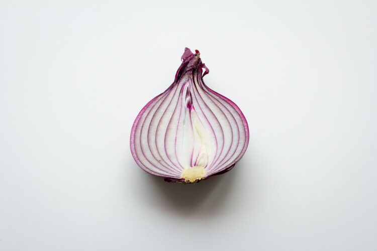 Pink and white garlic on white surface