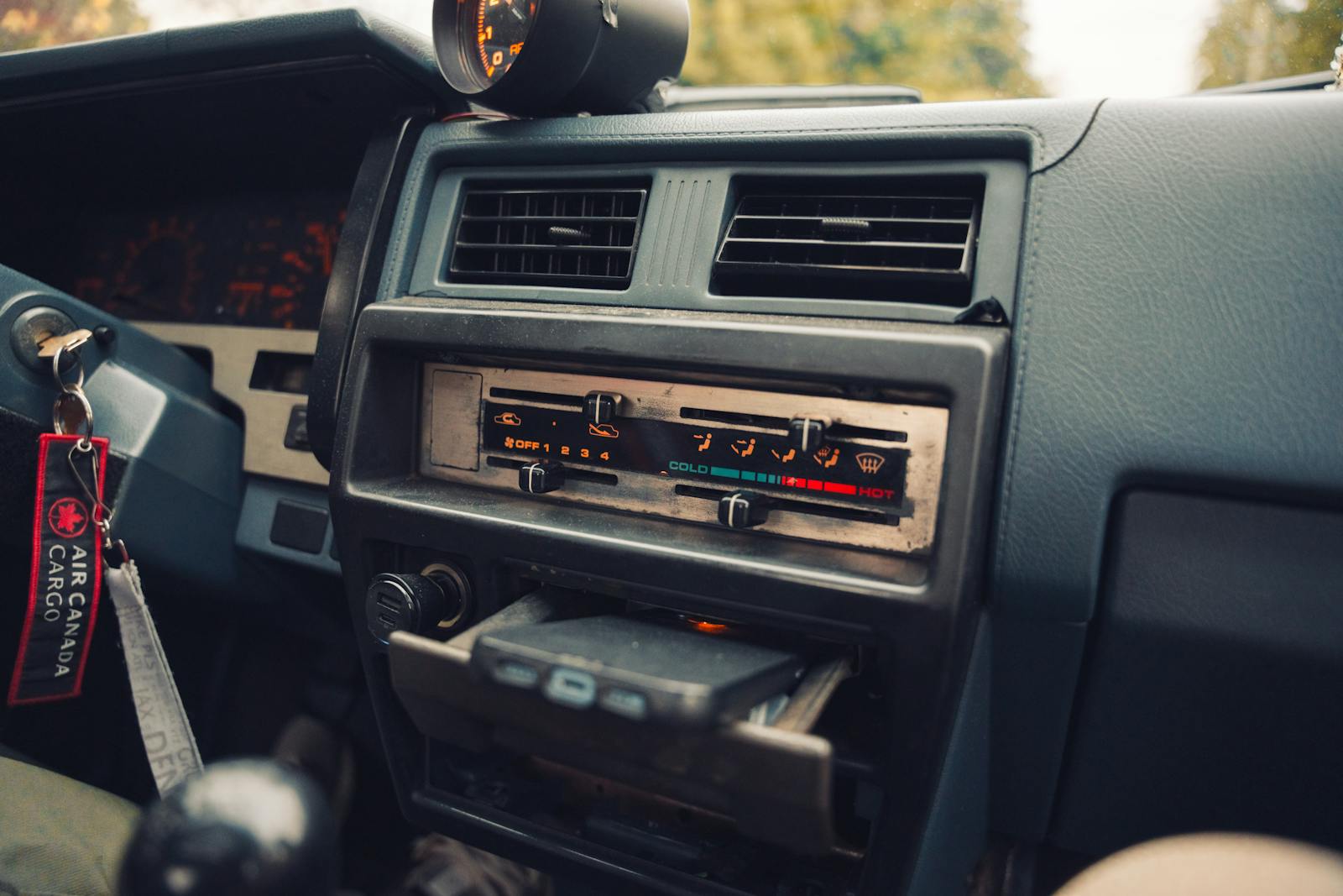 Detailed view of a vintage car dashboard highlighting controls and a keychain