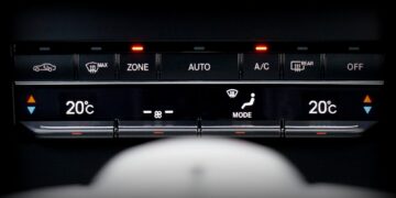 Close-up image of a car's climate control panel with digital temperature display.