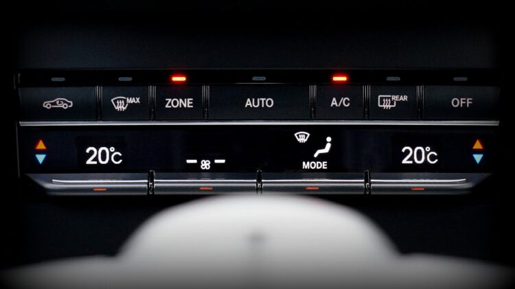 Close up image of a car's climate control panel with digital temperature display