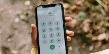 Close-up of emergency number dialed on smartphone held outdoors, emphasizing mobile technology's role in safety.