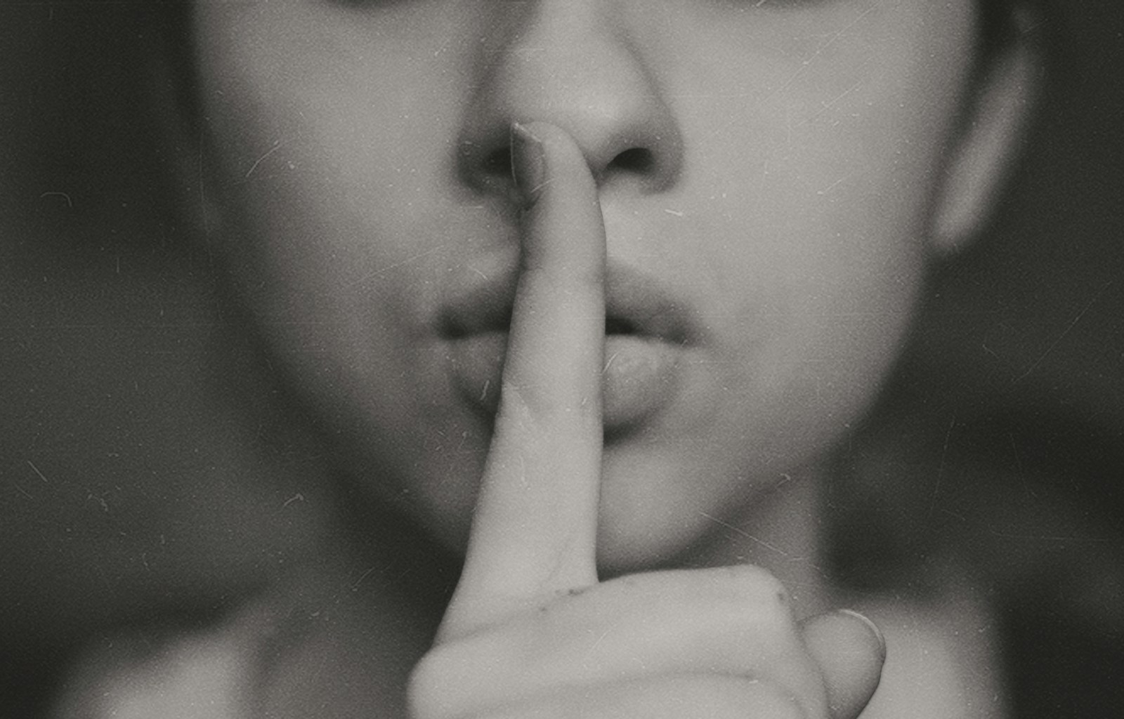 Grayscale photo of woman doing silent hand sign