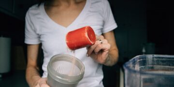woman in white crew neck t-shirt holding red plastic cup