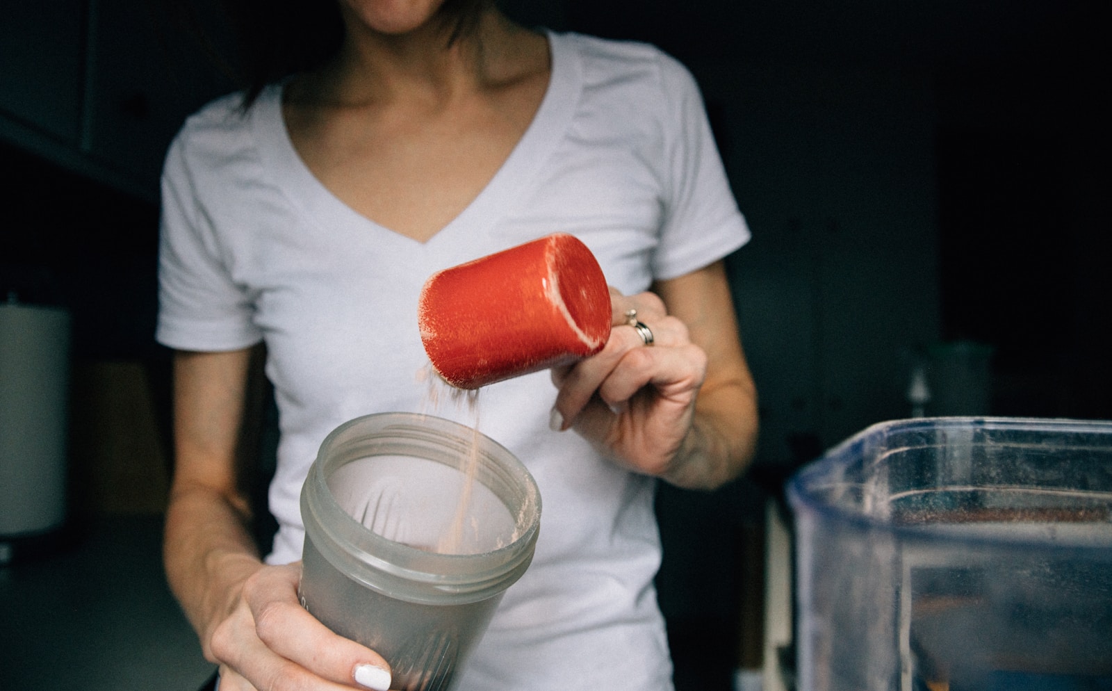 Woman in white crew neck t shirt holding red plastic cup