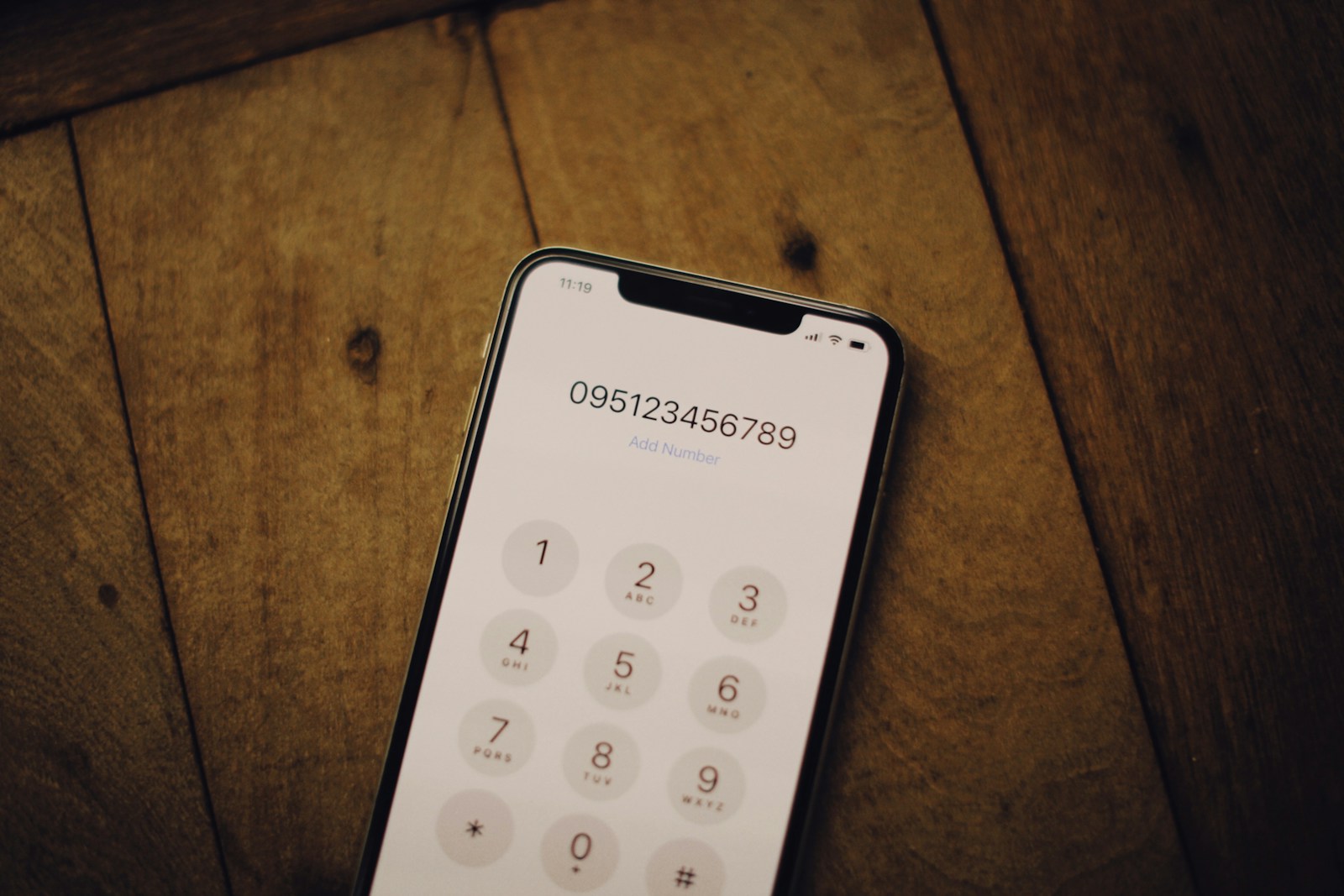A cell phone sitting on top of a wooden table