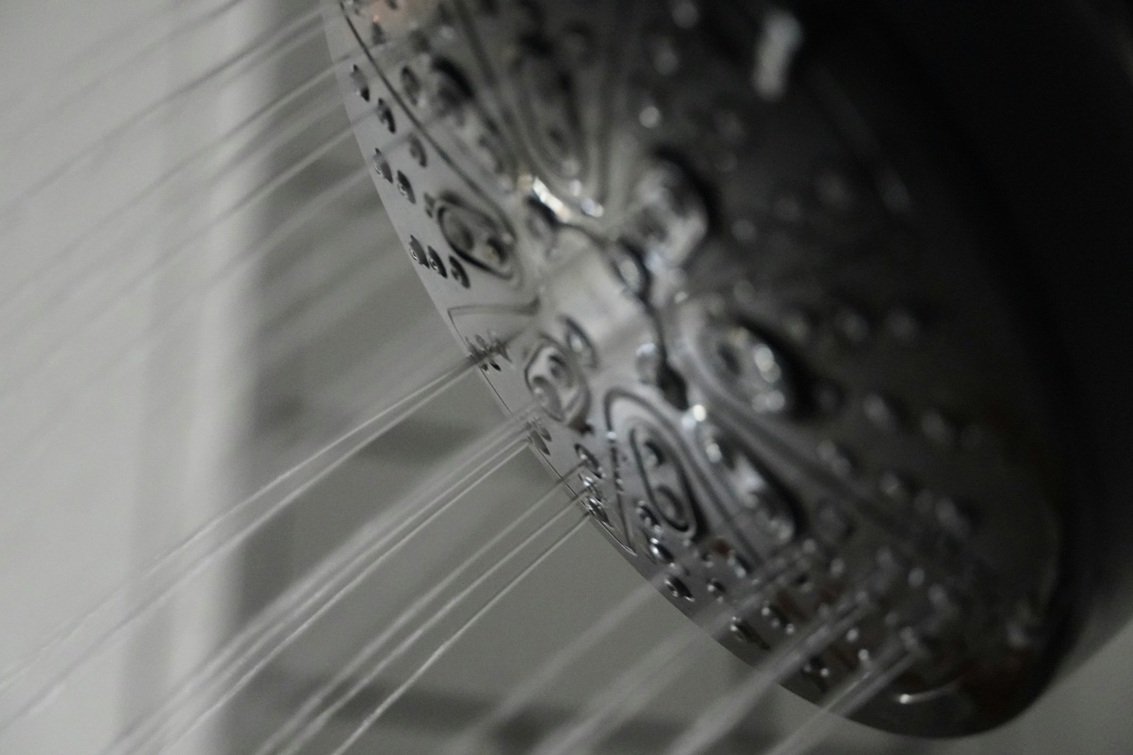 A close up of a shower head in a bathroom