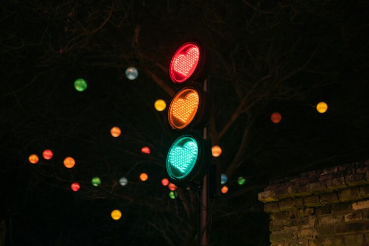 A traffic light with a heart on it at night