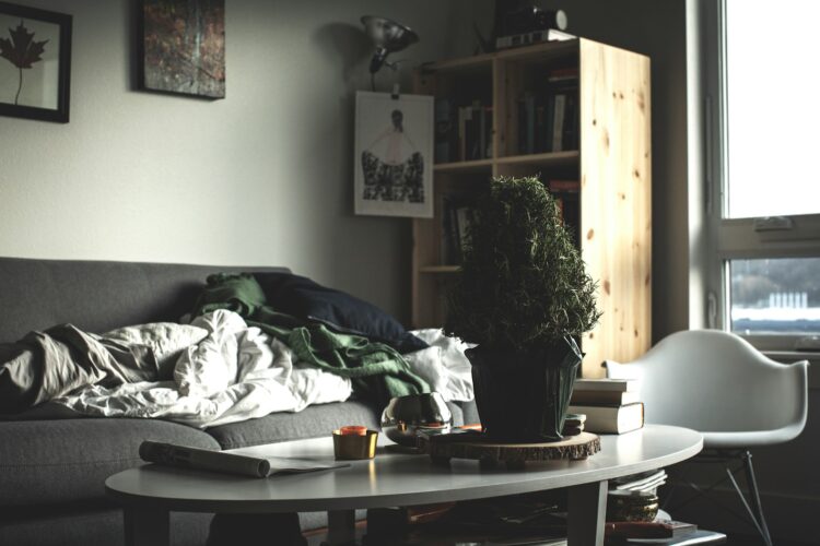 Oval white wooden coffee table near vacant sofa