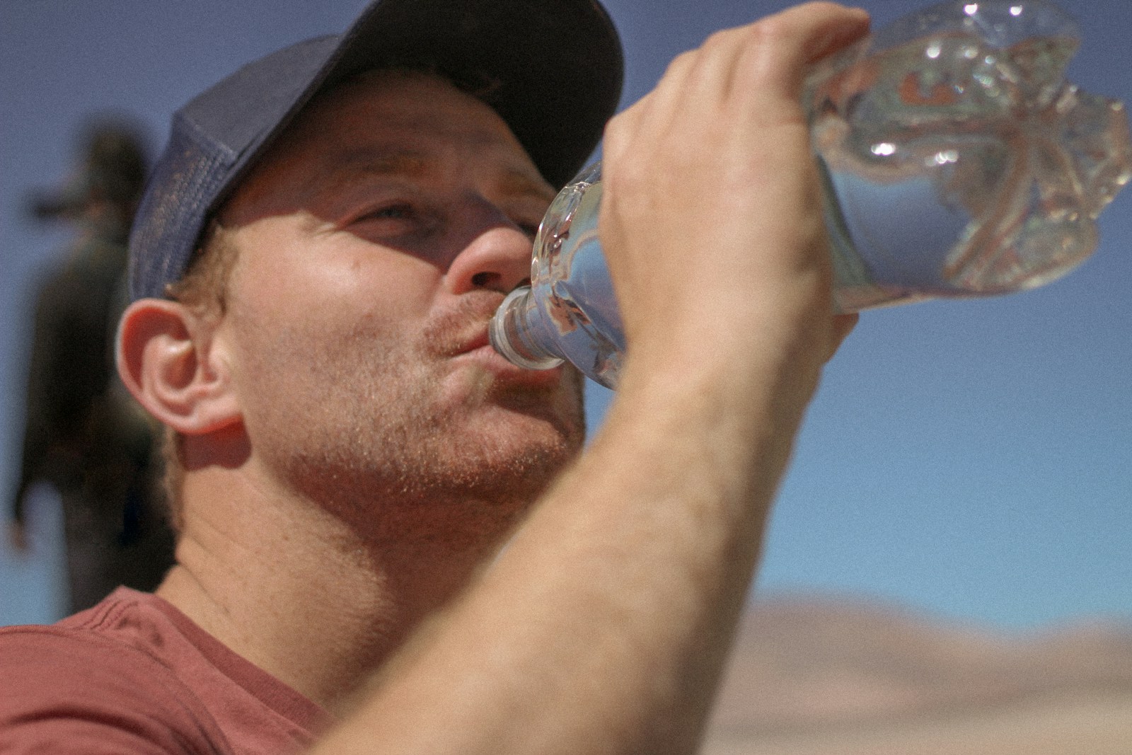 A man drinking water out of a bottle