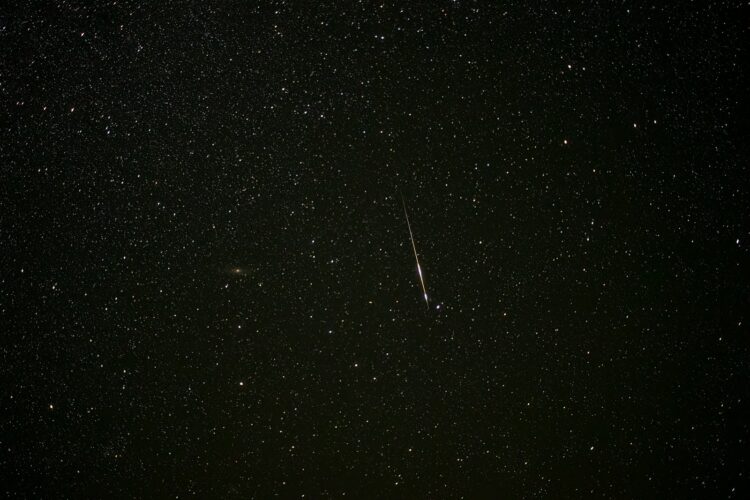 A dark sky with stars and a bright streak