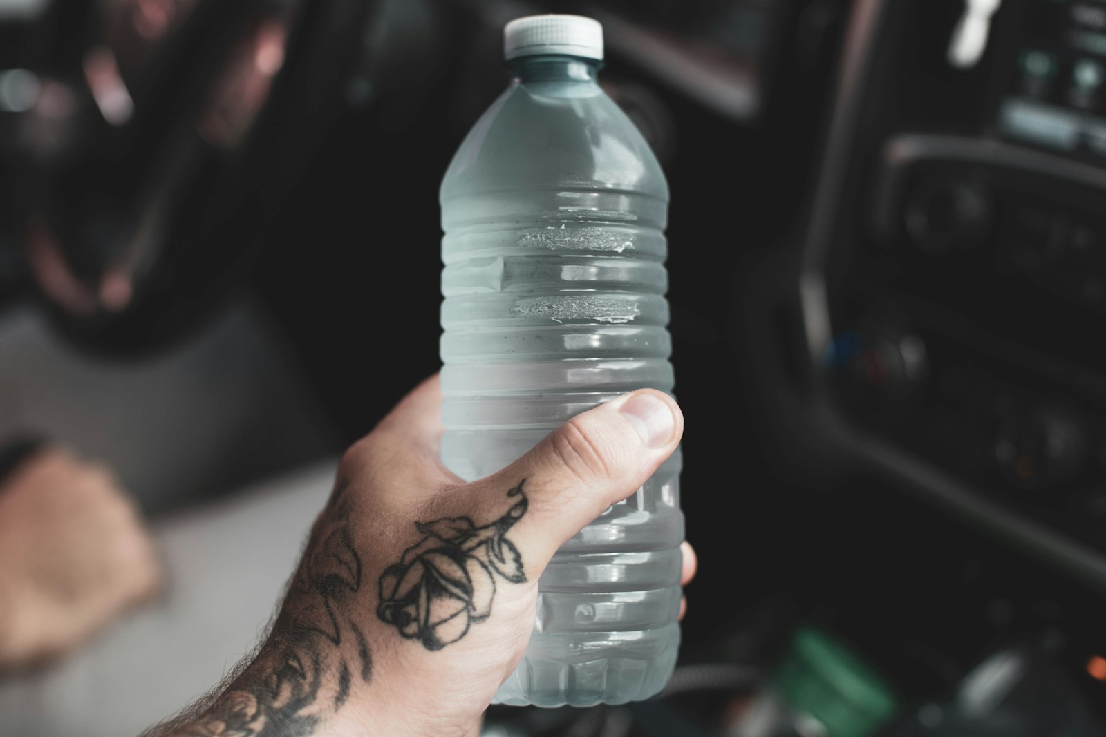 Person holding clear plastic bottle