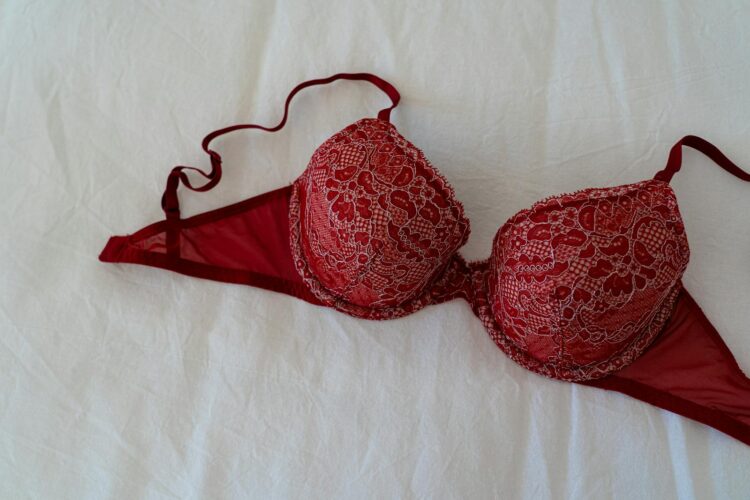A stylish burgundy lace bra elegantly displayed on a white fabric background offering a sense of luxury and intimacy
