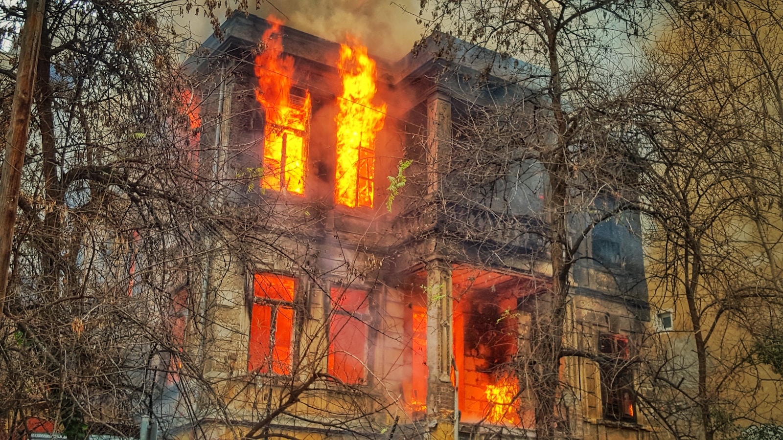 Photo of burning house near trees