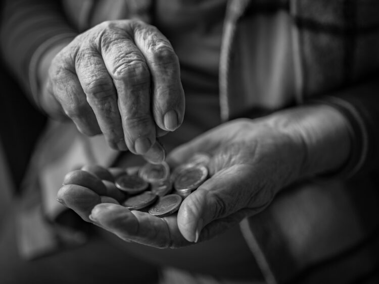 A black and white photo of a person holding a handful of coins