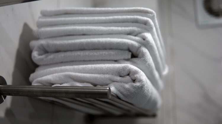 A stack of folded towels sitting on a towel rack