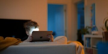 a person sitting on a couch using a tablet