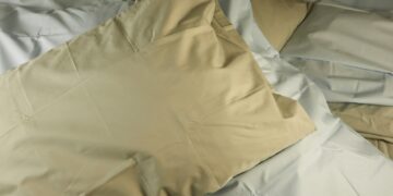 a pile of pillows sitting on top of a bed