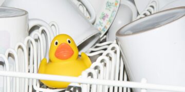 a yellow rubber duck sitting in a dishwasher