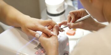 a woman getting her nails done at a nail salon