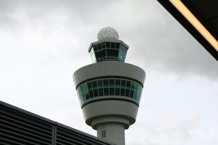 An airport control tower with a sky background