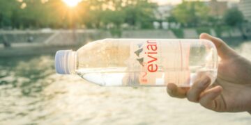 person holding clear plastic bottle during daytime