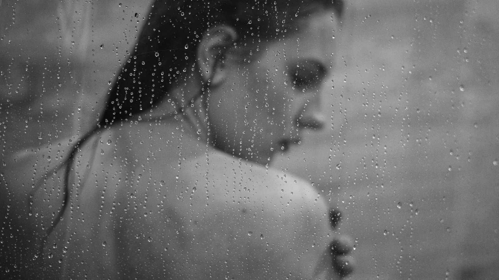 A black and white photo of a woman in the rain