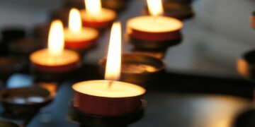 lighted candles on black metal candle holder