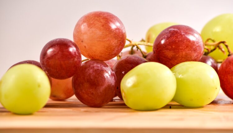 A bunch of grapes sitting on top of a wooden table