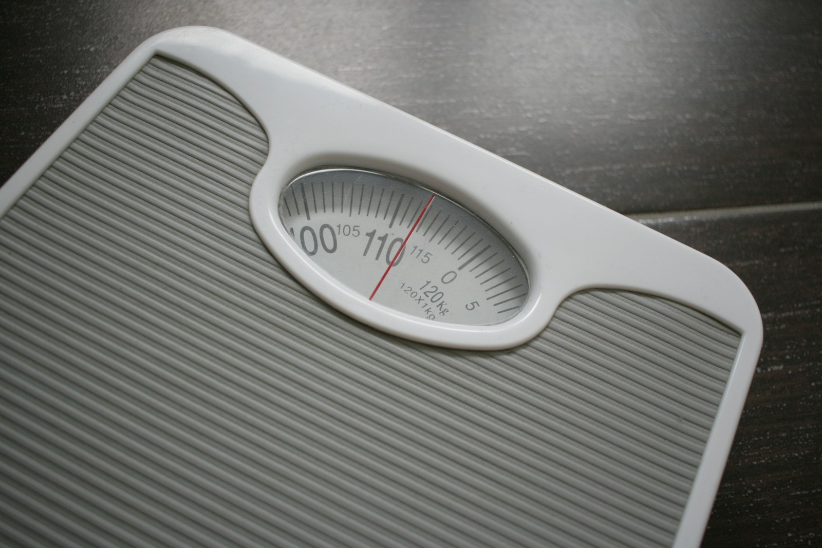 A bathroom scale sitting on top of a wooden table