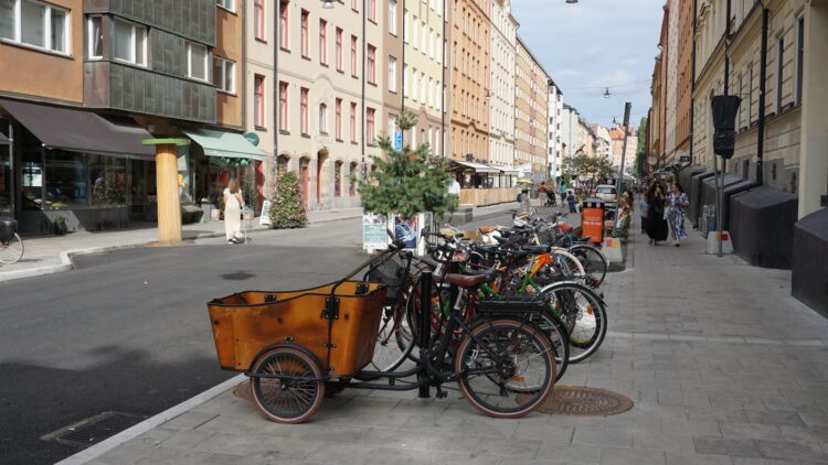 A row of bikes parked on the side of a street